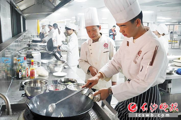 在长沙商贸旅游职业技术学院湘菜学院的实训厨房,锅勺碰撞声中飘出阵阵香气。 在长沙商贸旅游职业技术学院湘菜学院的实训厨房,锅勺碰撞声中飘出阵阵香气。